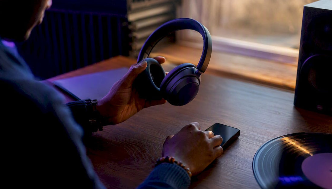 Hands holding headphones near music player