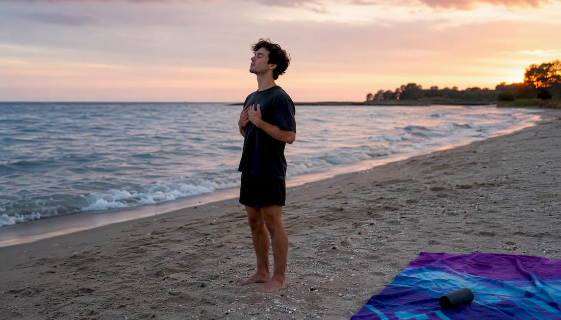 Person practicing breathing by lake at dawn