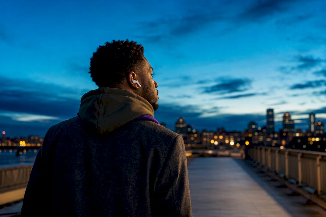 Person listening to music on rooftop at dusk