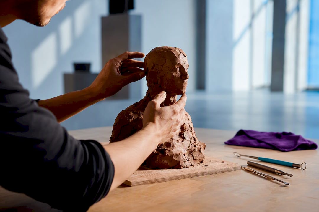 Hands revising a clay creative project