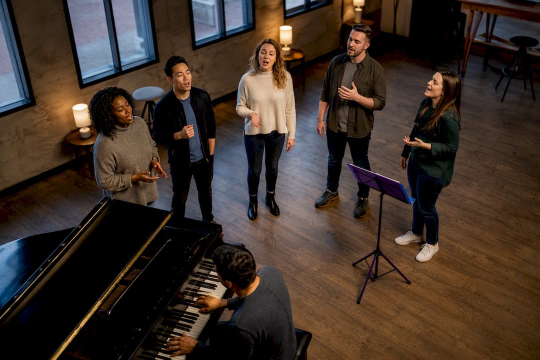 Pianist accompanying singers in rehearsal