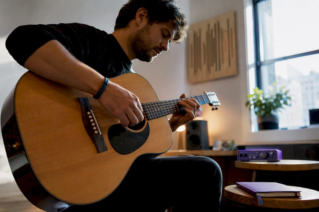 Musician beginning focused practice with guitar
